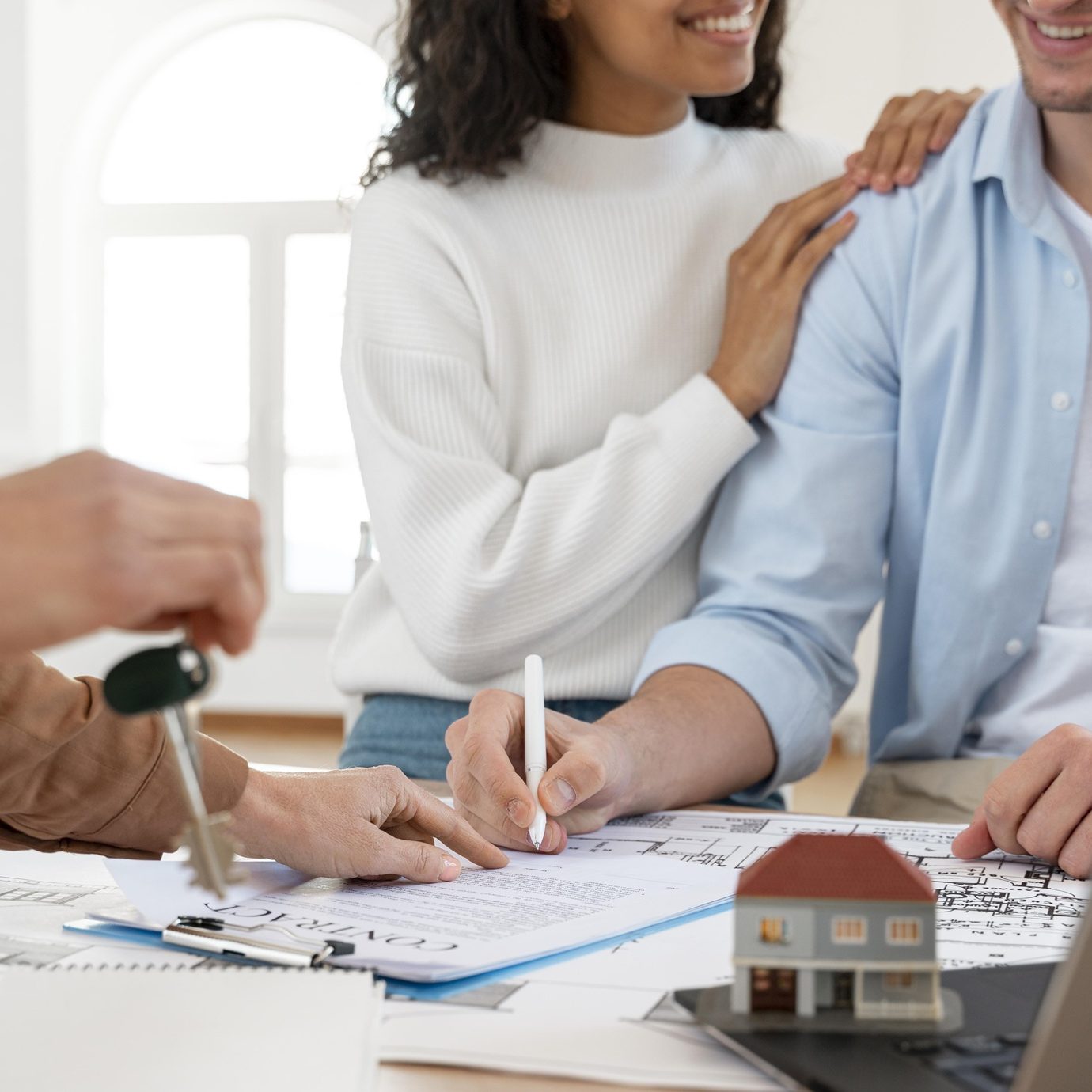 Agent reviewing paperwork with clients in a bright office.